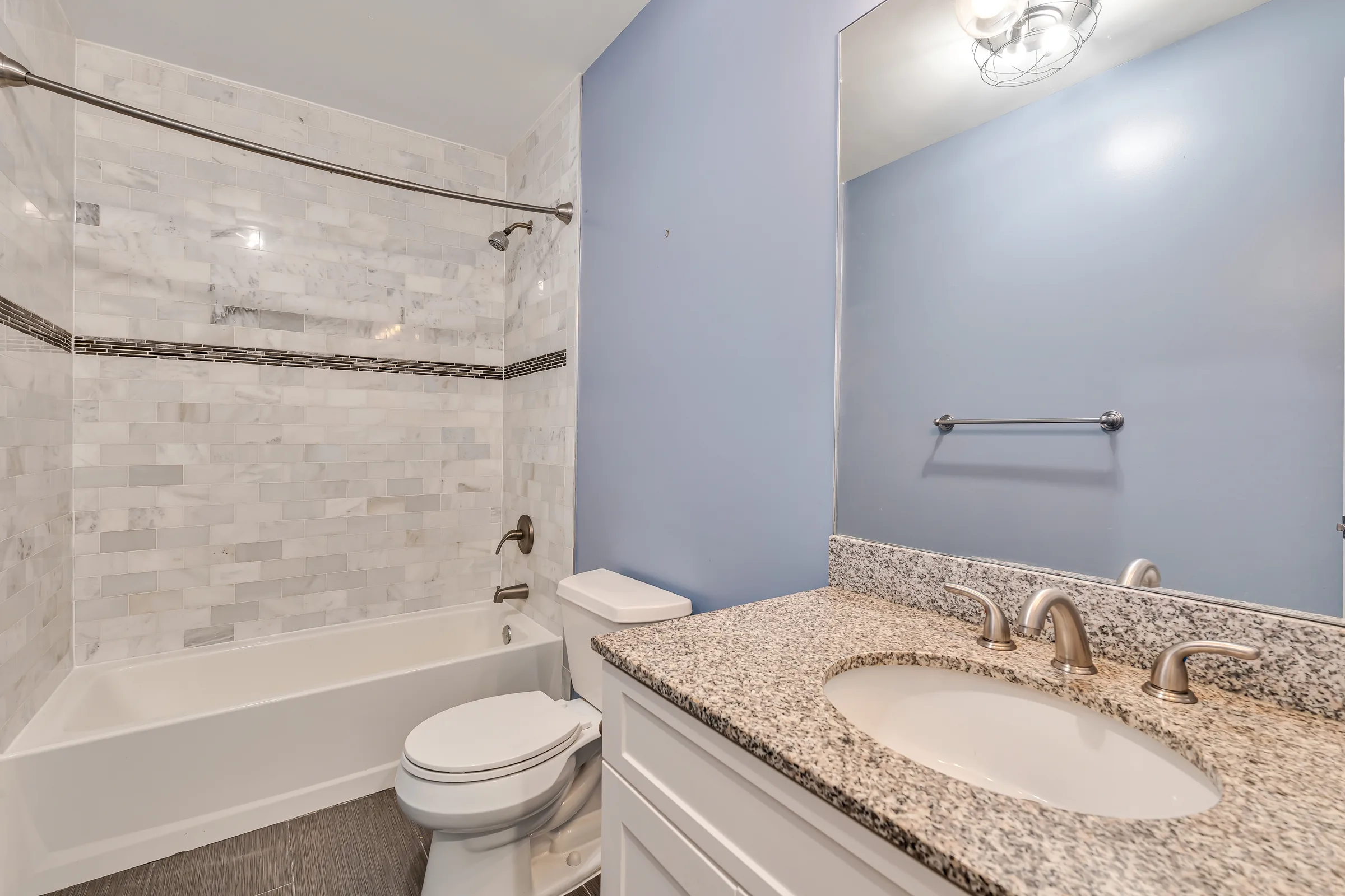 Full bathroom with a single vanity, tub, and marble-look tile at 829 Garden Street, Apartment B.