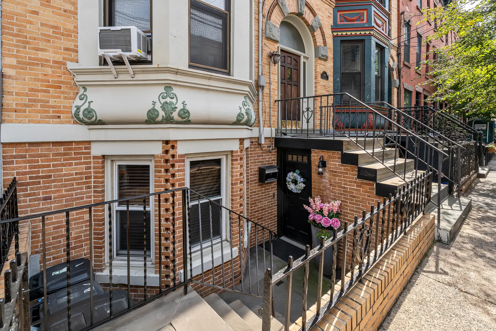 Garden-level entrance to Apartment B at 829 Garden Street, with the brick stoop and bay window in Uptown Hoboken.