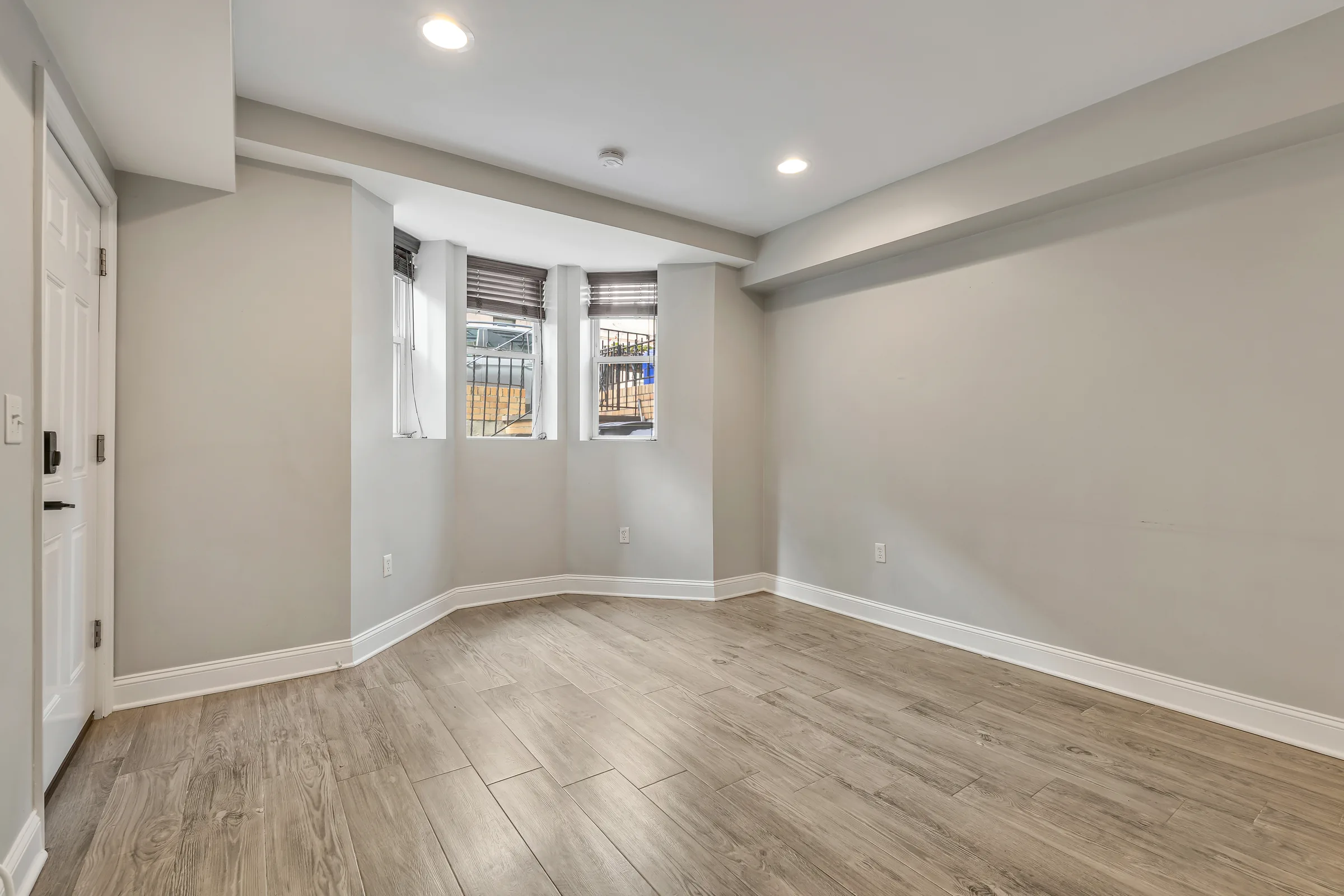 Living room seen from the entry door, with bay windows along the front wall at 829 Garden Street.