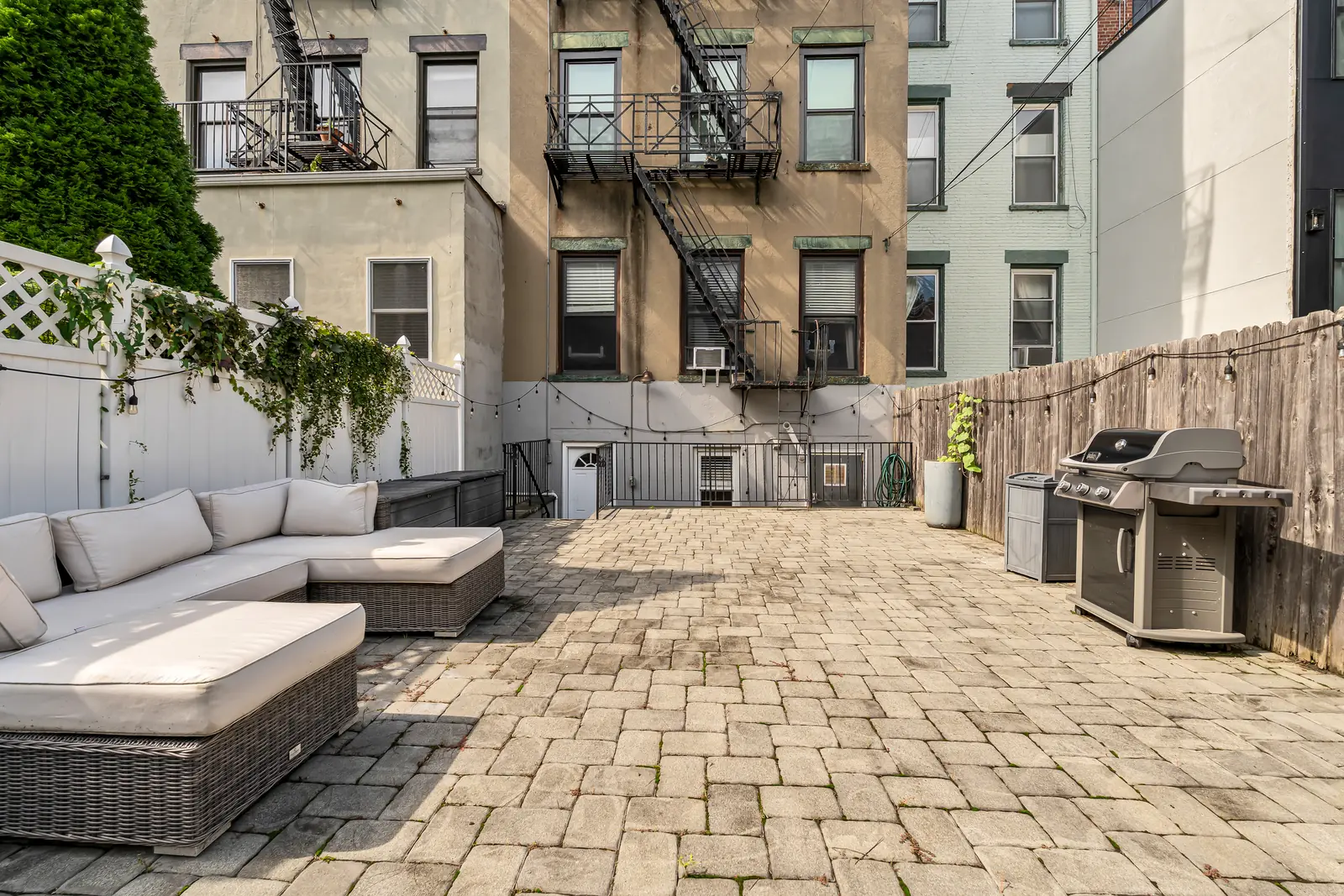 Paver patio with string lights along the fence at 829 Garden Street, Apartment B.
