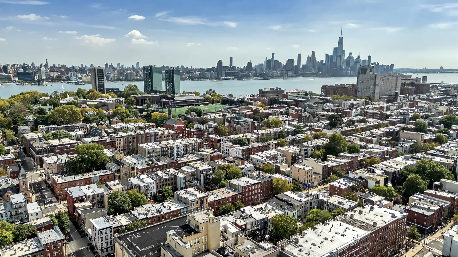 Aerial view of Hoboken rooftops and the Hudson River, with the Lower Manhattan skyline to the south, above 829 Garden Street.